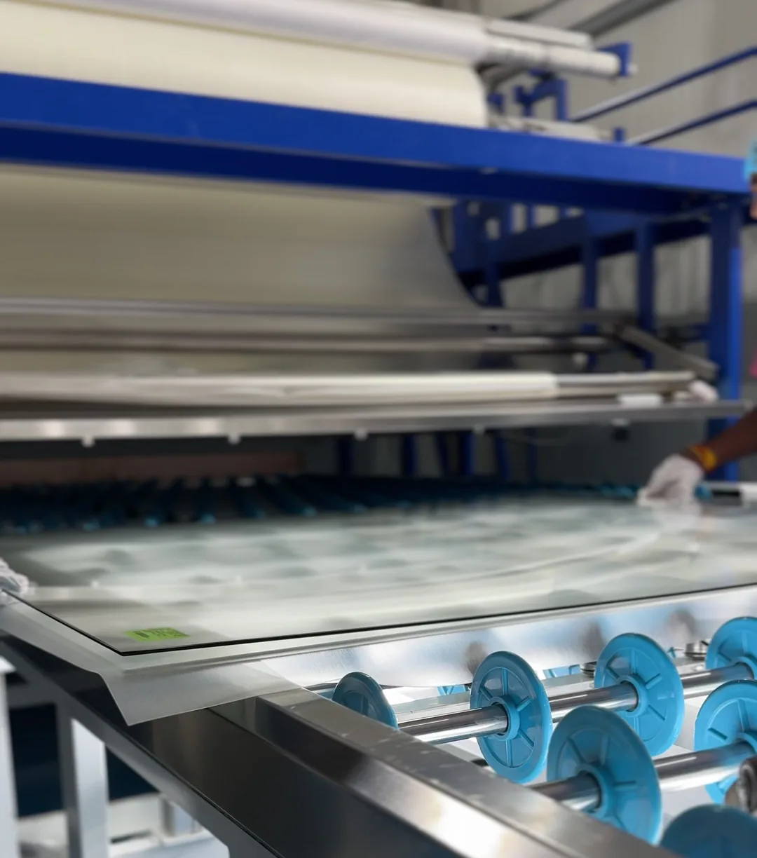 A sheet on the lay-up rollers of the jumbo lamination line at the ARG plant, the interlayer roll above it